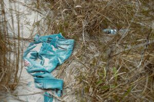 Día Internacional de Cero Desechos en la industria textil; pantalón tirado en la playa