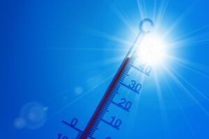 Termómetro marcando alta temperatura bajo un sol intenso, símbolo del calentamiento global y del reto climático en Navarra, relacionado con la transición ecológica, la neutralidad climática 2050 y la correcta gestión de residuos electrónicos (RAEE) por parte de empresas.