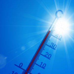Termómetro marcando alta temperatura bajo un sol intenso, símbolo del calentamiento global y del reto climático en Navarra, relacionado con la transición ecológica, la neutralidad climática 2050 y la correcta gestión de residuos electrónicos (RAEE) por parte de empresas.