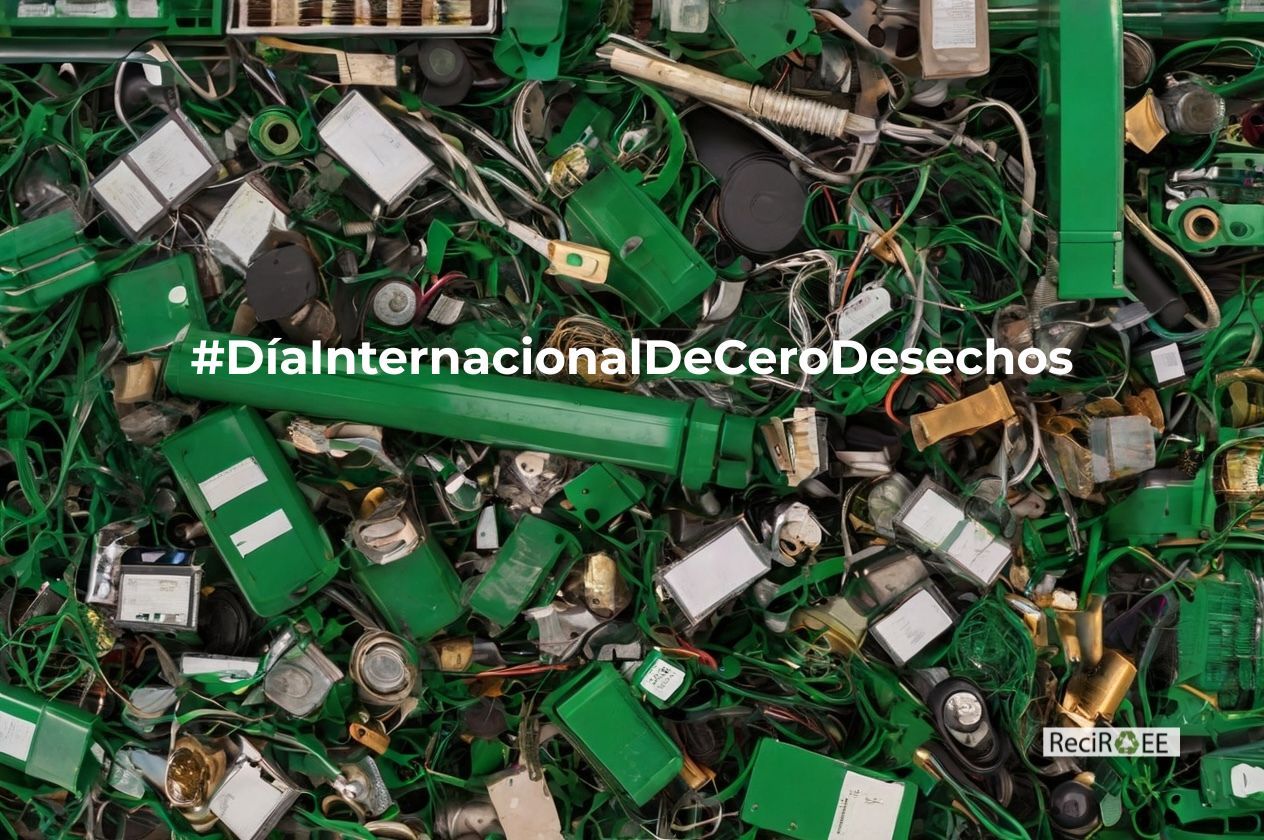 Montón de residuos electrónicos en tonos verdes (cables, piezas, dispositivos y componentes mezclados) con el texto “#DíaInternacionalDeCeroDesechos” en el centro y el logo de ReciRAEE en la esquina inferior derecha