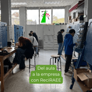 Aula-taller en Navarra con personas trabajando en paneles y mesas de prácticas, en una actividad vinculada a la gestión de residuos electrónicos, con el texto “Del aula a la empresa con ReciRAEE”, imagen que muestra la conexión entre formación práctica, clasificación de RAEE y aprendizaje del trabajo en una empresa autorizada.